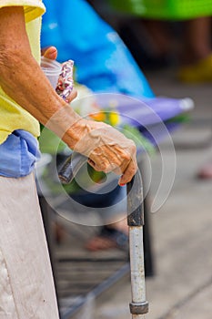 Old woman hand leans on walking stick, close-up