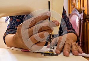 Old woman hand`s using a sewing machine