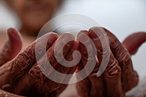 Old woman hands praying for god rising her hands