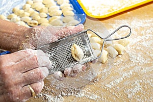 Old woman hands preparing fresh italian pasta gnocchi. Concept Italian Traditional cuisine
