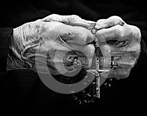 Old woman hands with a rosary