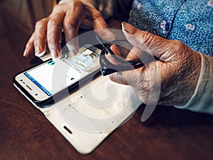 Old woman hands using mobile device