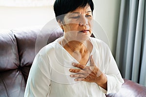 Old woman having heart attack and grabbing her chest