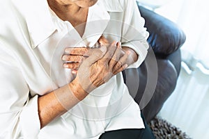 Old woman having heart attack and grabbing her chest