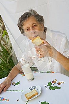 An old woman is having her breakfast