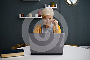 Old woman having video conference on laptop