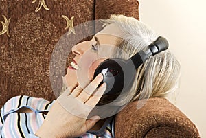 Old woman with headphones in sofa