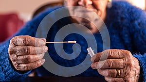 Old woman holding a cotton swab for nose to collect a possible positive COVID-19