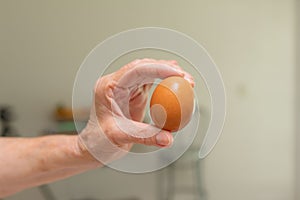 Old woman holding an egg. Ingredients for making a veggie salad