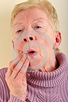 old woman holding her painful jawbone photo