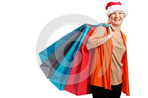An old woman holding presents/bags in santa hat.