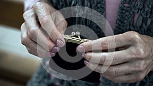 Old woman holding purse, social insecurity, lack of money, poverty, close-up