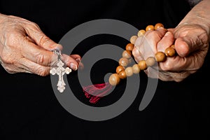 Old woman holding wooden rosary and cross ,prayer ,woman pray ,faith