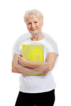 An old woman holding a workbook. photo