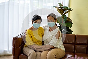 Old woman  in hospital with daughter taking care with protective face mask.  Health care and medicine concept