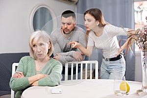 Old woman ignoring her daughter and son-in-law arguing with her