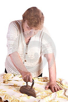 The old woman irons a cloth