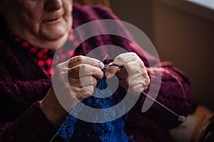 The old woman knits garments