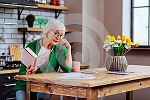 Old woman leaning on hand having look at vedic drawings