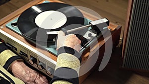 Old woman listening vinyl record on player
