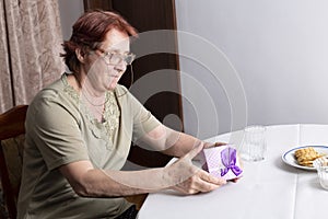 Old woman looking at gift box accepting present