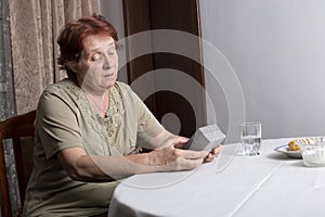 Old woman looking at gift box accepting present