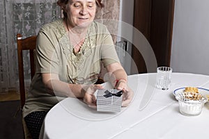 Old woman looking at gift box accepting present