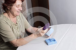 Old woman looking at gift box accepting present