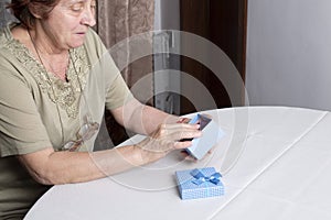 Old woman looking at gift box accepting present