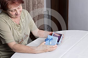 Old woman looking at gift box accepting present