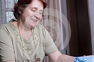 Old woman looking at gift box accepting present