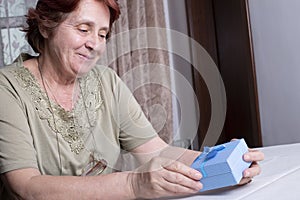 Old woman looking at gift box accepting present