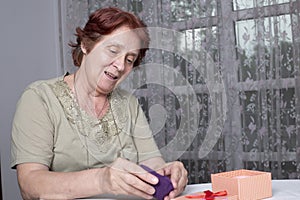 Old woman looking at gift box accepting present