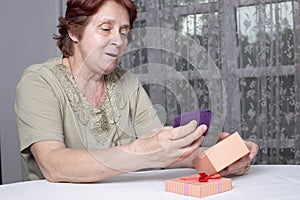 Old woman looking at gift box accepting present