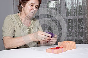 Old woman looking at gift box accepting present