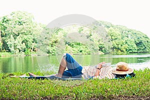 An old woman lying and reading in the park