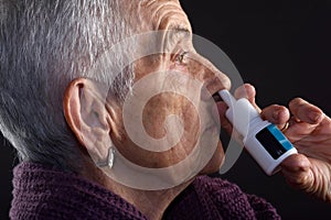 Old woman with nasal spray photo