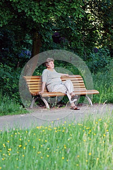 Old woman on a park bench thinking