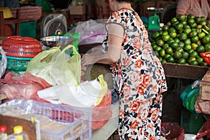 Old woman is peeling off jackfruit at the wet market