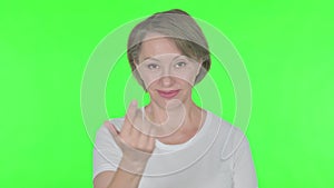 Old Woman Pointing at Camera, Inviting on Green Background
