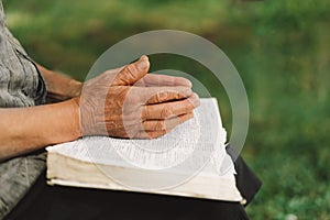Old woman praying for hope or reading holy bible