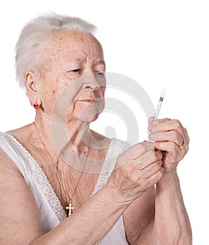 Old woman preparing syringe for making insulin injection