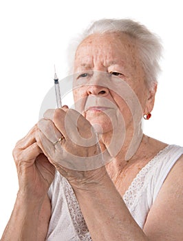 Old woman preparing syringe for making insulin injection