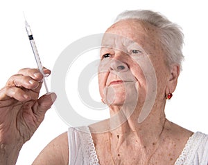 Old woman preparing syringe for making insulin injection