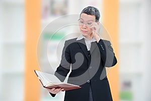 Old woman reading book having problem with her eyes