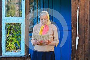 The old woman is reading the newspaper.