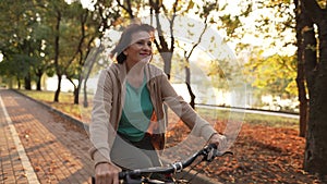 Old woman riding bicycle in public park