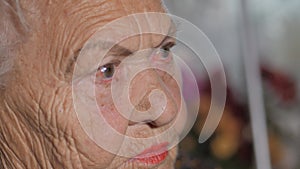 Old woman`s face close-up, side view. Skin with old wrinkles.