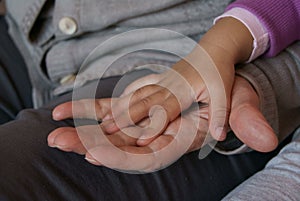 Old woman hand and little girl hands together