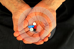 The old woman& x27;s hands are holding a handful of pills. Old man is holding medicine. Treatment of elderly, pensioners